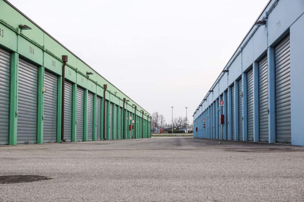 Two rows of storage units around a clear central driveway, with green units on the left and blue units on the right.
