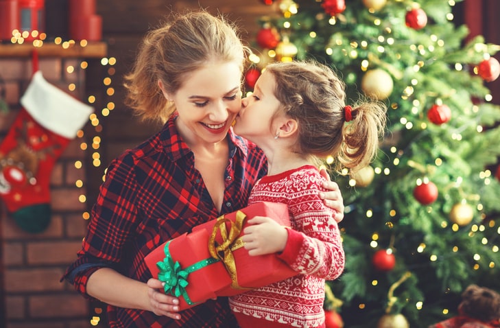 Daughter kissing mom on the cheek while exchanging gifts
