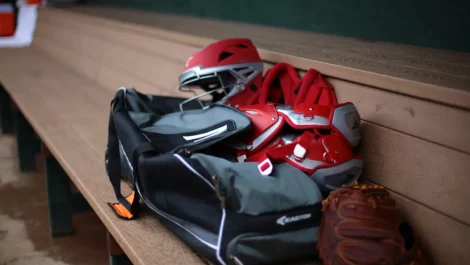 Sports equipment over a bench after a game.