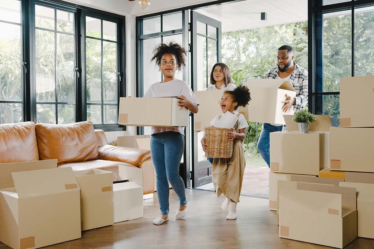 Family bringing in boxes to their new house during their summer move.