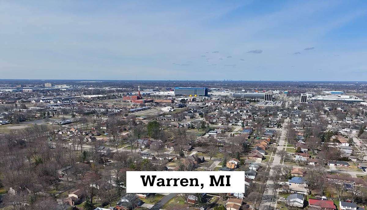 Aerial drone view of Warren, MI, showing the city with housing areas and surrounding commercial area.